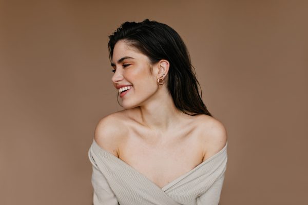 Appealing girl smiling in studio. Indoor photo of blissful female model with black hair.